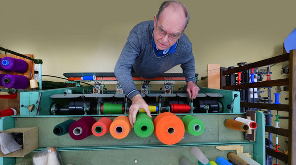 Ein Mitglied der Arbeitsgruppe Textiltechnik an einer Textilmaschine