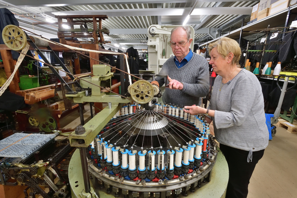 Zwei Arbeitsgruppenmitglieder prüfen eine Textilmaschine