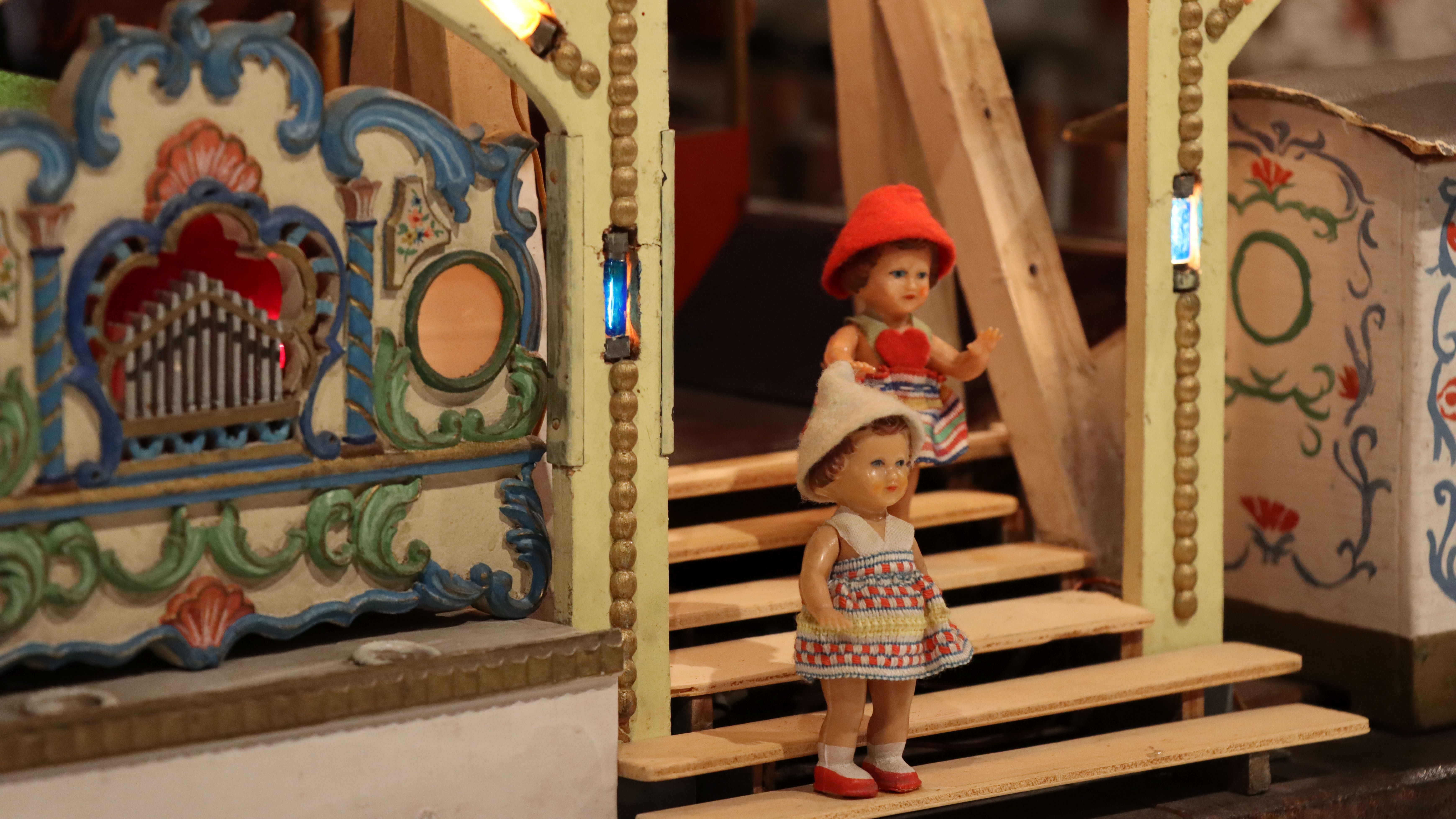 Puppenkarussel aus Holz, reich verziert, Detailansicht mit zwei Puppen